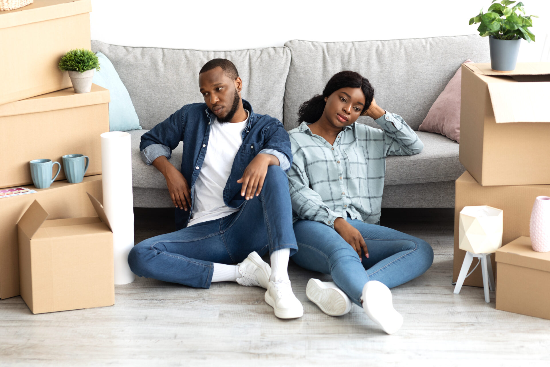 Portrait Of Tired Black Couple Sitting On Floor Exhausted After Moving To New Apartment